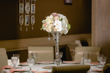 A view from afar on a bouquet in high vase standing in the middl