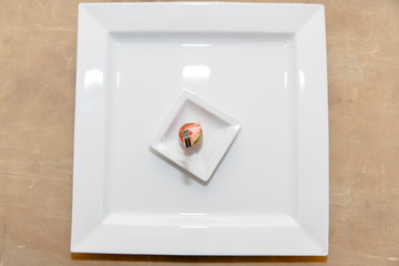 Fish appetizer lie on a white square plate