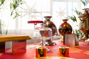 Empty glass dishes stand behind old Russian samovars on a buffet