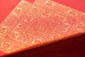 Fototapeta premium Golden orienal design on an orange tablecloth