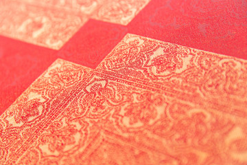 Square golden design on a red-orange tablecloth