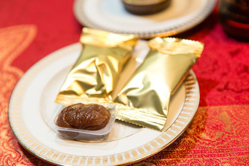 Sweets packed in a golden paper lie on the dinner plate