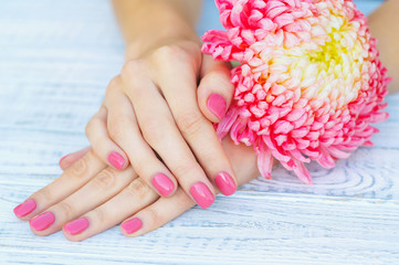 Stylish manicure with pink fingernails and pink flower
