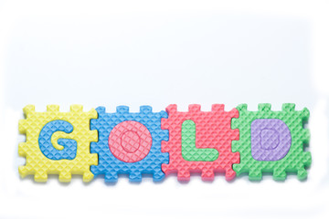 Puzzle pieces with word gold on a white background.