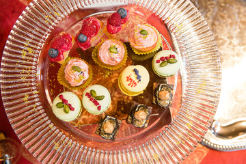Tasty cupcakes stand on a glass serving dish