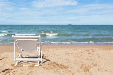 Fototapeta na wymiar Empty white wooden beach chair on tropical beach