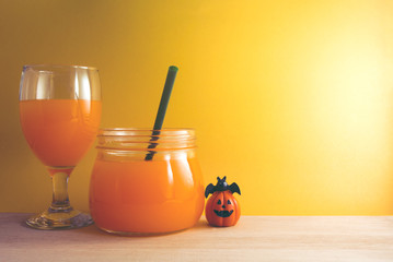 orange juice and pumpkin bat on yellow wall
