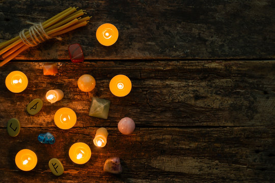 objects for divination, runes and candle on a wooden background