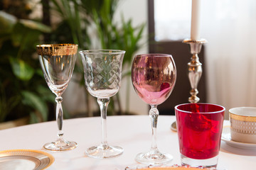 Different colored wineglasses stand on the dinner table