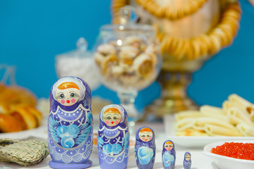 Pretty Russian nesting dolls stand behind a red caviar on the wh