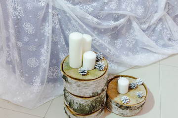 White candles and cones lie on the parts of birch trunk