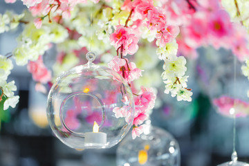 Glass balls with candles hang from a blooming tree