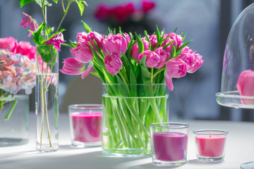 Pink and violet flowers surround a bouquet of tulips