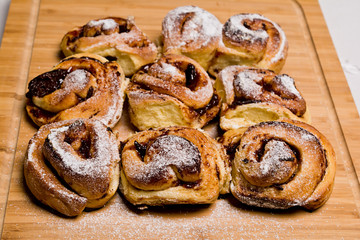 Homemade fresh baked yeast buns with plum jam. Sprinkled with icing sugar.