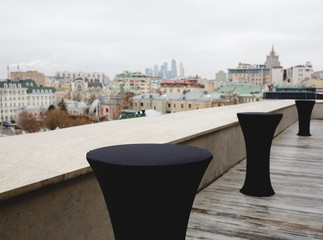 High bar tables covered with black cloth stand on the roof