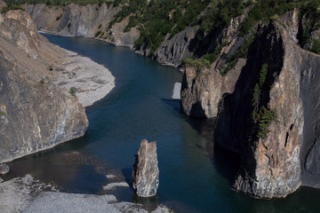 Fototapeta na wymiar Single stone pillar in the riverbed. River Omulyovka. Magadan Region. Russia.