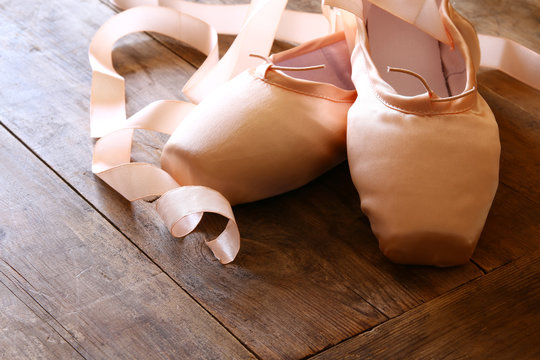 Image of silk pointe shoes on wooden floor