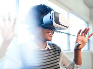 Cool millennial black woman exploring virtual reality glasses in an open-concept space