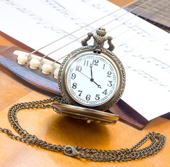 Antique pocket watch on guitar.
