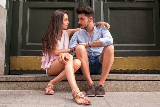 Portrait of beautiful couple in casual wear hugging in the stree