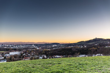 skyline of Linz, Austria with mountains at sun dawn