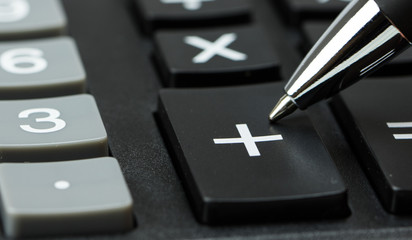 Taschenrechner mit Stift auf Plus