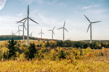 Wind turbine farm over blue sky at sunset