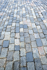 Street paved with gray cobblestones vertical view close-up