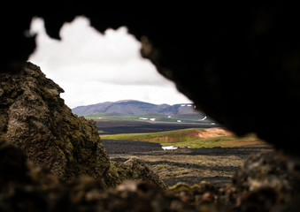 Icelandic landscape. Krafla volcano through a hole in mountain.