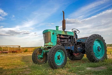 Foto op Canvas old tractor in field © spyrakot