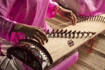 Woman play a traditional korean string instrument : the gayageum