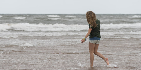 Girl walking on the beach, Prince Edward Island, Canada