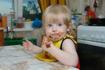 Child ,kid, dirty chocolate sitting at the table.