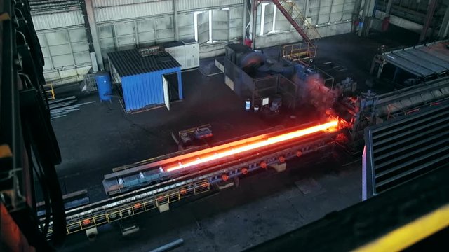 Ironworks plant. Working Machines moves burning hot billet. Top view