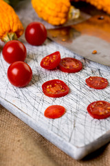 Small red cherry tomatoes spill out of on  old wooden table in r