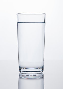 Glass of healthy still drinking water on white