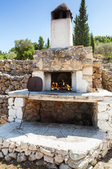 White outdoor stone oven with burning fire
