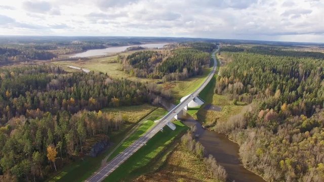 Beautiful aerial view of road bridge over the river surrounded by forest