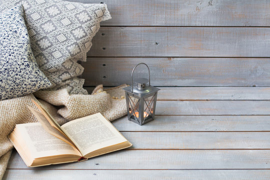 Cushions, plaid, Christmas lantern and old book on the white woo
