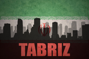 abstract silhouette of the city with text Tabriz at the vintage iranian flag background