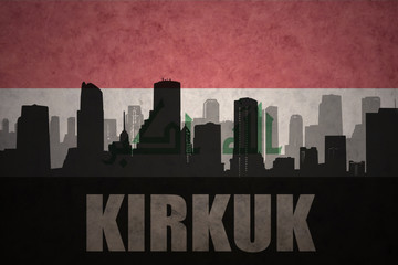 abstract silhouette of the city with text Kirkuk at the vintage iraqi flag background