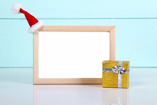 picture frame with gift boxes on wooden floor, Santa hats. space for text. mock up