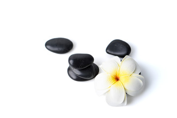 Hot spa stones and exotic frangipani flower isolated on white