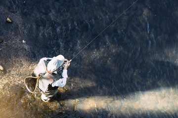 Fly fisherman using flyfishing rod.