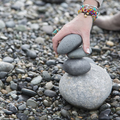 Close-up of a person's hand making stack of stones, Deception Pa