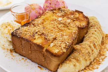 Fototapeta na wymiar Honey toasts with banana , vanilla and strawberry ice-cream - dessert