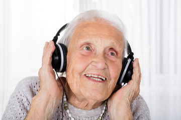 Senior Woman Using Headphone At Home