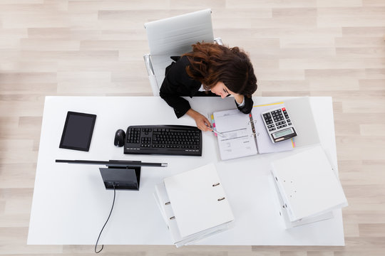 Depressed Businesswoman Sitting At Office Desk