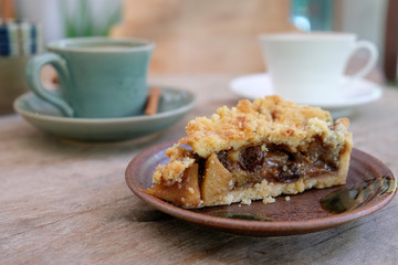 Apple pie and coffee on wooden table.