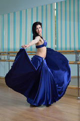Beautiful woman in arabic costume dancing in motion, oriental or belly dance